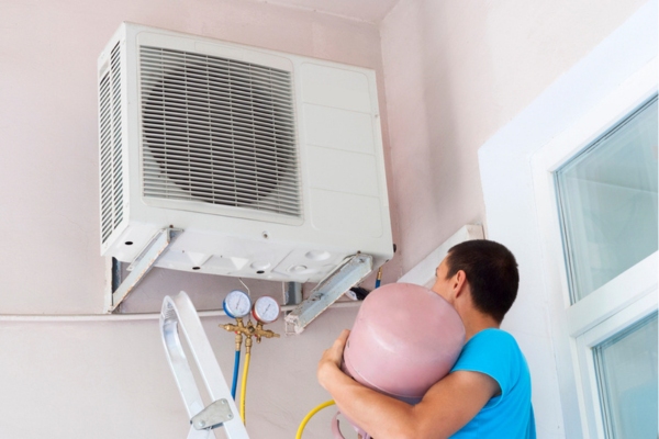 HVAC technician refilling refrigerant in an air conditioner