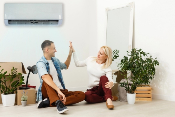 couple doing a high five in the living room with ductless HVAC system