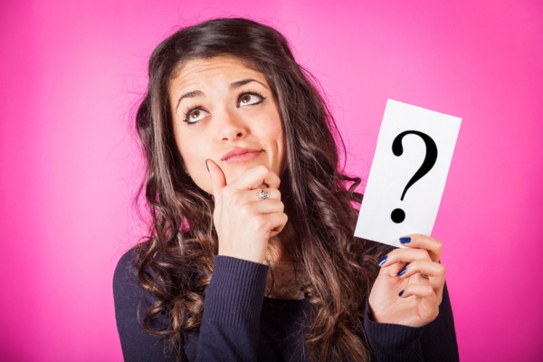 woman holding question mark sign depicting air conditioner maintenance common questions