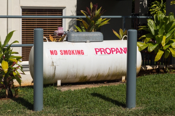 Large propane tank in landscaped garden