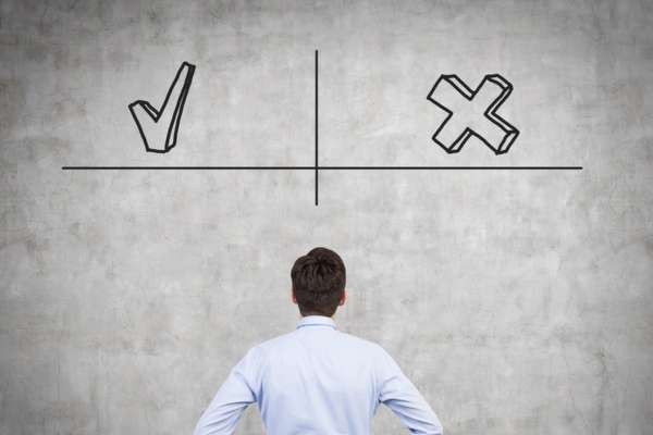 man looking at big check and x mark on a wall depicting advantages and challenges of DIY Propane Tank Landscaping
