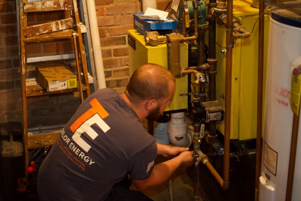 Taylor Energy HVAC technician installing Energy Kinetics System 2000 boiler