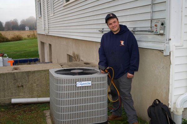 Taylor Energy air conditioner service technician checking for leaking refrigerant