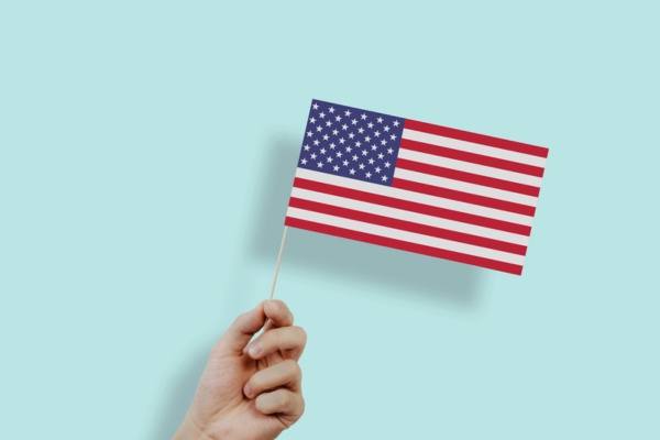 cropped view of a hand waving a small US flag depicting American-Made Quality