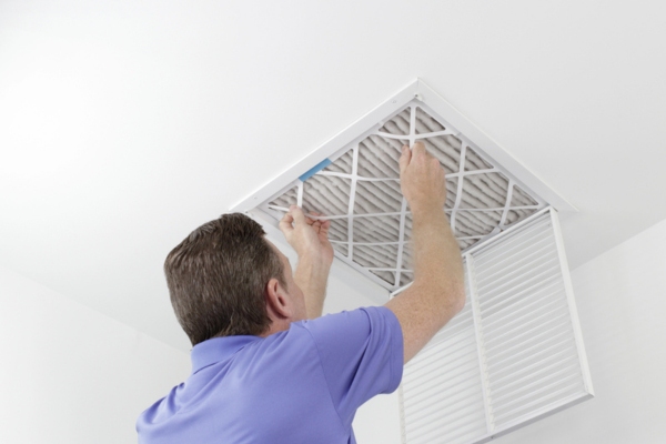 homeowner checking air conditioner filter