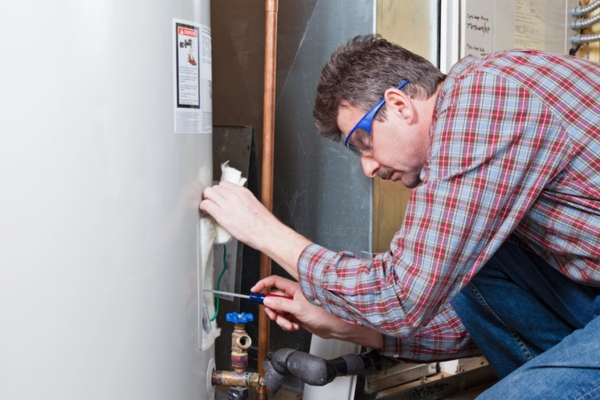 plumber performing water heater maintenance