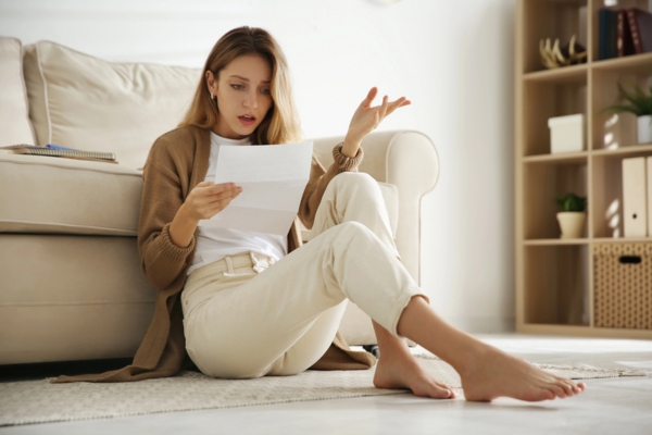shocked woman while looking at high energy bill