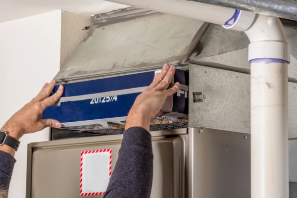 HVAC technician replacing furnace filter