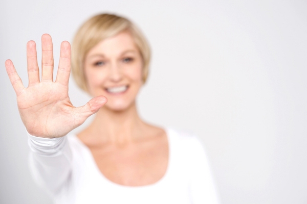 blurred woman in the background holding 5 fingers up depicting 5 Ways To Tell If Your HVAC Blower Motor Needs Replacing