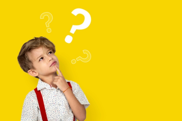 young boy looking at question marks on yellow background depicting how often you should change your HVAC filter