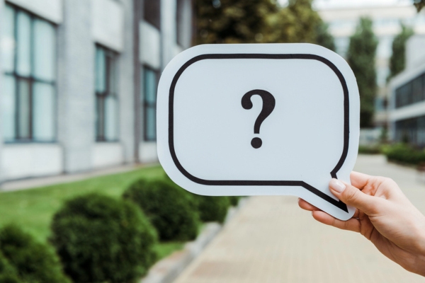 Cropped view of woman holding speech bubble with question mark depicting FAQs about AFUE vs AFUE2