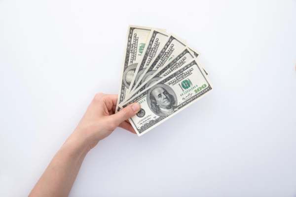 cropped view of a woman's hand holding dollar bills