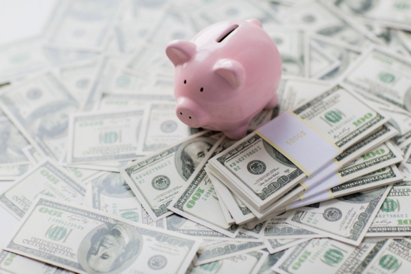 piggy bank on top of dollar bills depicting savings