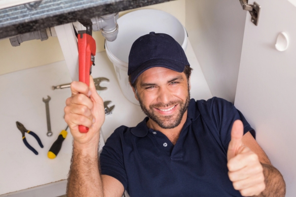 plumber doing a thumbs up while fixing under kitchen sink