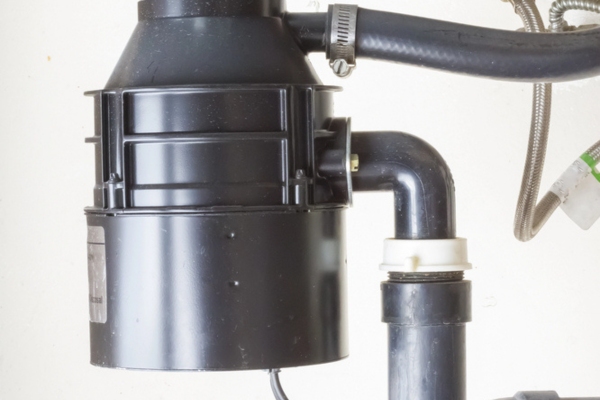 close up of garbage disposal unit under the sink