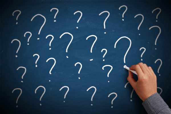 man writing question marks on chalkboard depicting How Long Do Garbage Disposals Last FAQs