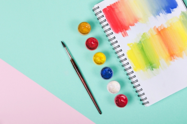 Bottles with paint and brush with colored notepad depicting diesel color