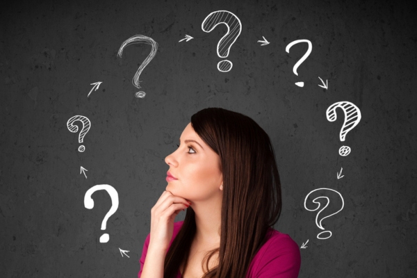 woman thinking with question marks around her depicting deciding between heat pump and furnace