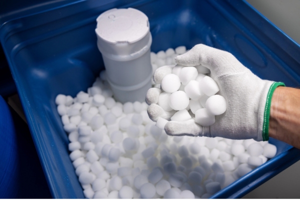 plumber filling water softener with salt tablets