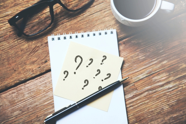 question marks on paper with beside a cup of coffee and a pen depicting FAQs about Cracked Heat Exchanger