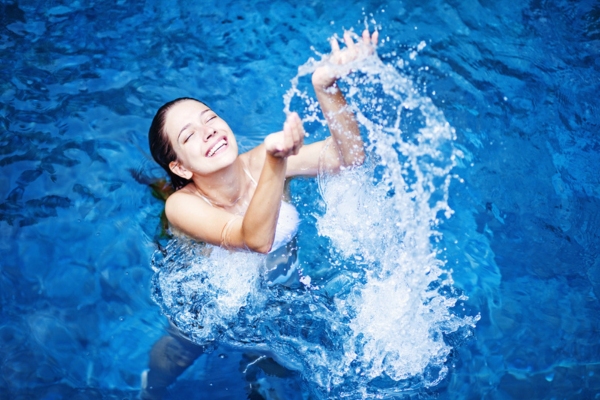 woman splashing water in a heated pool