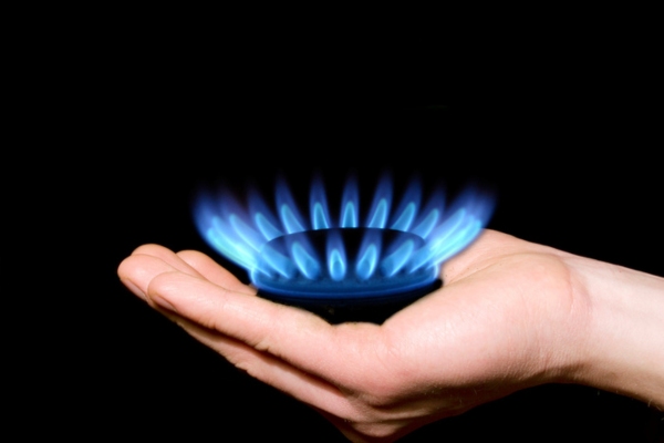 hand holding flame from a burner powered by propane