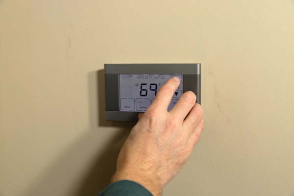 homeowner adjusting thermostat