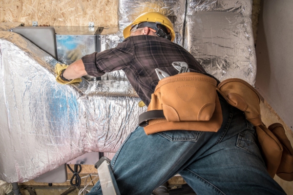 HVAC technician tending to a home's ductwork system
