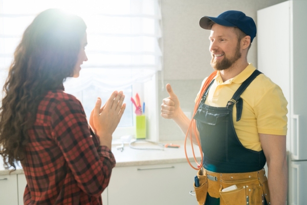 plumber doing a thumbs up and a clapping homeowner
