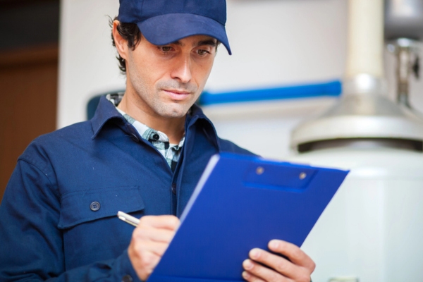 plumber writing down notes after plumbing inspection