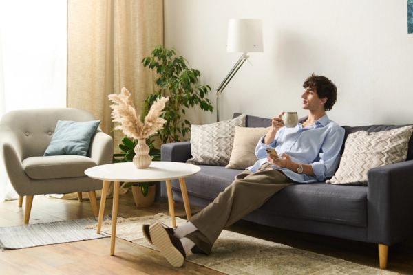 young man lounging comfortably at home feeling cozy with working HVAC system