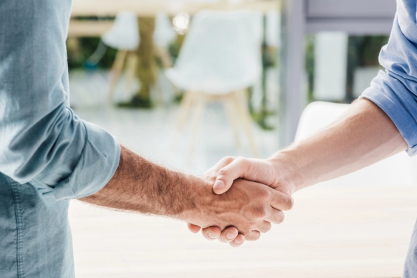 cropped view of two men shaking hands depicting service agreement