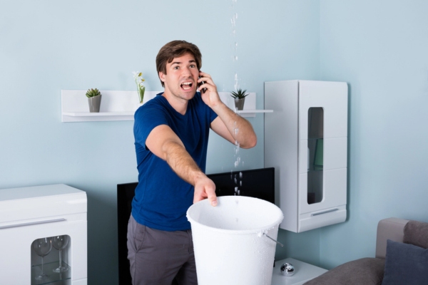 man calling plumber while there is water leak
