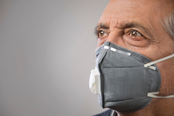 senior man wearing a pollution mask depicting indoor air quality