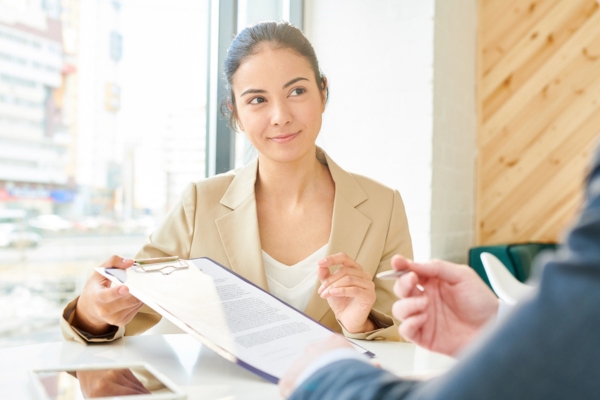 woman explaining HVAC service agreement on a clipboard to a customer