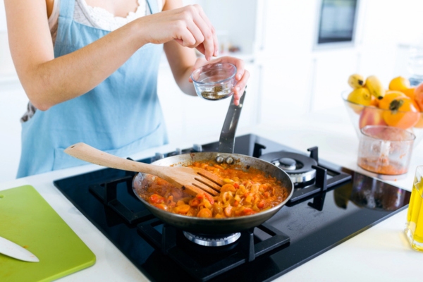 cropped view of a woman cooking using propane stove
