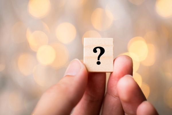 hand holding a wooden chip with a question mark depicting Air Conditioning Safety FAQs