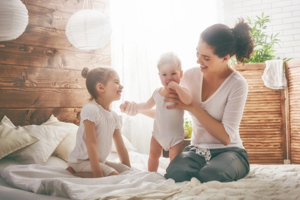 mother and children lounging in the bedroom and staying cool with air conditioner