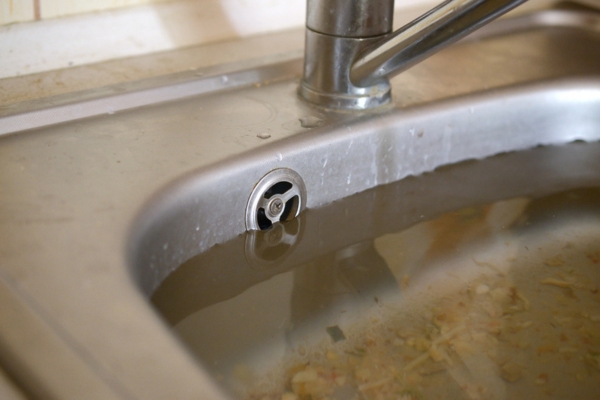overflowing kitchen sink depicting clogged garbage disposal