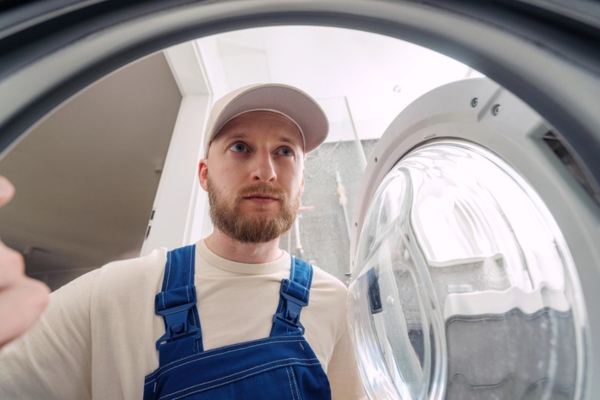 repairman looking inside washing machine