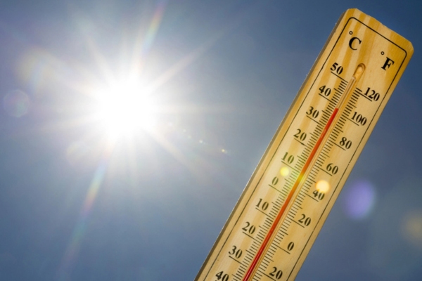 thermometer under the summer sun depicting warm weather