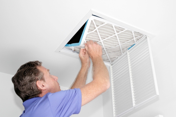 homeowner inspecting home HVAC filter