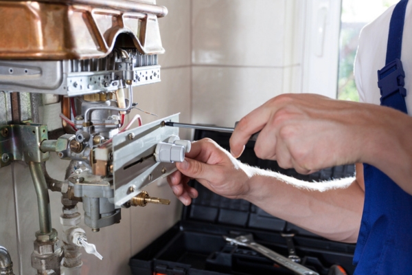 plumber tinkering with water heater