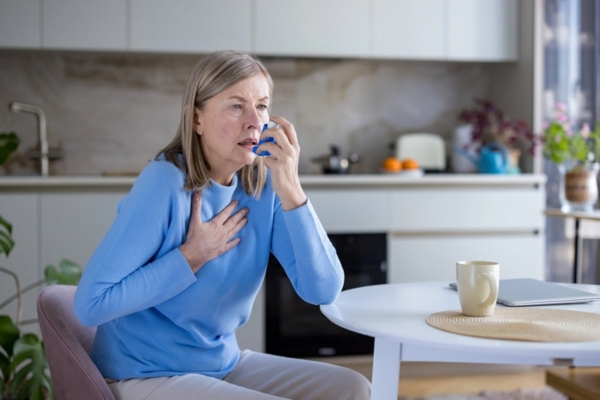senior woman about to use inhaler due to asthma attack caused by poor indoor air quality