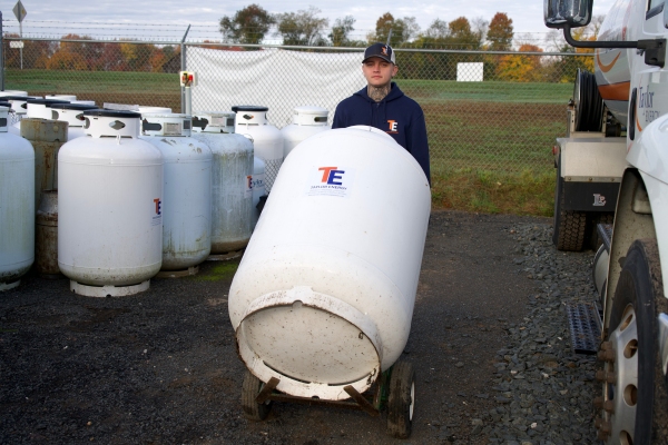 Enfield, CT technician moving a propane tank on a hand truck for delivery